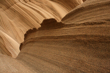 Sandy background in brown tones in a left-center upper direction. The lines create organic shapes in an upper direction with a marked protruding contour