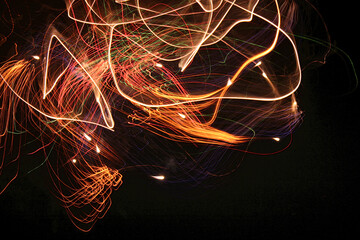 Long exposure fireworks shot. Disorderly formation of intertwined colored flashes spiraling from...