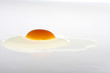 Side view of fried egg on transparent surface (light table) on white background