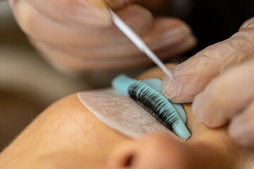 makeup artist doing eyelash lamination for a client