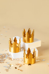 Three Golden crowns on white podium with star confetti background for Dia de Reyes Magos day (...