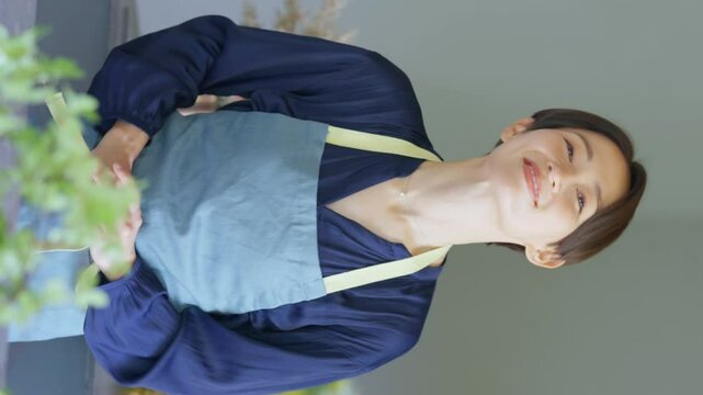 カメラ目線でお辞儀をするお花屋さん_縦