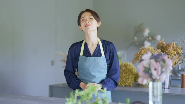 カメラ目線でお辞儀をするお花屋さん