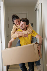 Young newlywed couple moving into their new house. They are homeowners. New beginnings. Plants in...