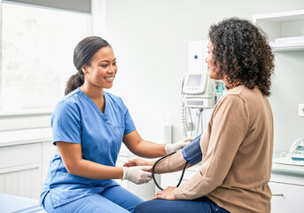 Nurse taking patient's blood pressure in medical clinic for health checkup