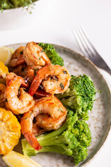 Shrimp and vegetables cooked in the oven for a healthy lunch on a white table