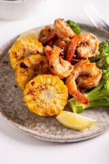Shrimp and vegetables cooked in the oven for a healthy lunch on a white table