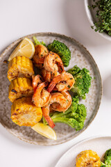 Shrimp and vegetables cooked in the oven for a healthy lunch on a white table
