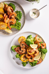 Shrimp and vegetables cooked in the oven for a healthy lunch on a white table
