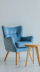 A soft blue armchair positioned next to a light wooden side table on a minimalist background brings a serene and inviting atmosphere
