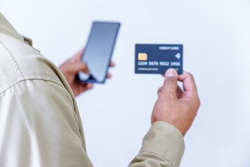 A person holding credit cards and a phone, ready for a transaction or payment.