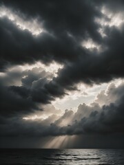 Obraz premium A moody sky with heavy gray clouds and soft sunlight peeking through, creating a dramatic contrast between light and shadow 