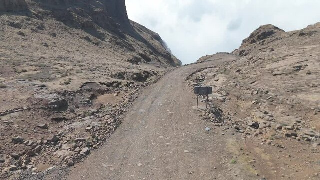 fly down from top of Sani Pass, over hairpin switchbacks to reveal lower road section shrouded in thick clouds and mist