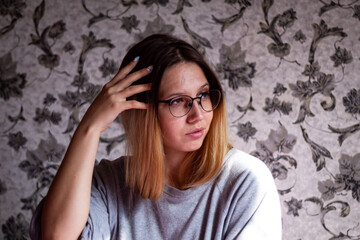 Attractive young woman in pajamas posing while sitting in bed. Color horizontal photo at home.