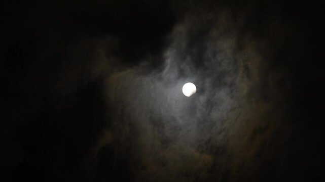 Partial Full Moon Eclipse Behind Clouds &ndash; Night Sky Video - Dramatic time lapse of full moon in partial eclipse phase behind fast moving clouds