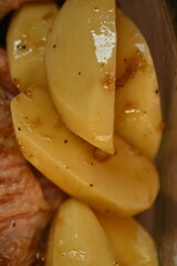 marinated chicken  and potatoes in sauce in a dish before baking, the texture of potatoes and meat cooked for dinner 