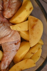marinated chicken  and potatoes in sauce in a dish before baking, the texture of potatoes and meat cooked for dinner 