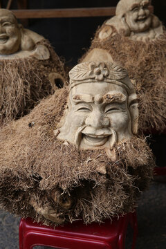 Traditional national wooden art, souvenirs in Old Town of Hoi An city, Vietnam. Vietnamese handicraft, craft made from wood, beautiful handcraft. Fummy wooden human faces, sculpture for sale in shop