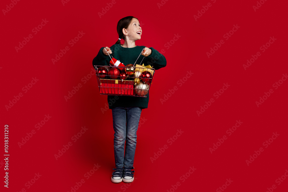 Poster Full size photo of cute little girl shop basket gifts empty space christmas festive time isolated on bright red color background