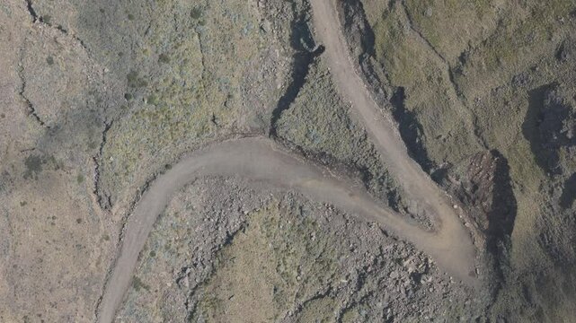 Top down view of Sani Pass. Dirt track cuts through mountainside, many switchbacks