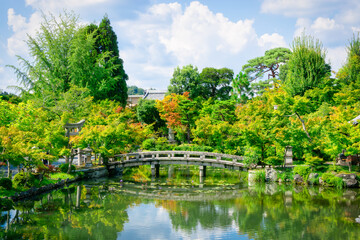 Obraz premium Traditional Japanese Garden, Kyoto. Bridge in Japanese Garden during summer. Refections in the water. Heian Jingu Garden.