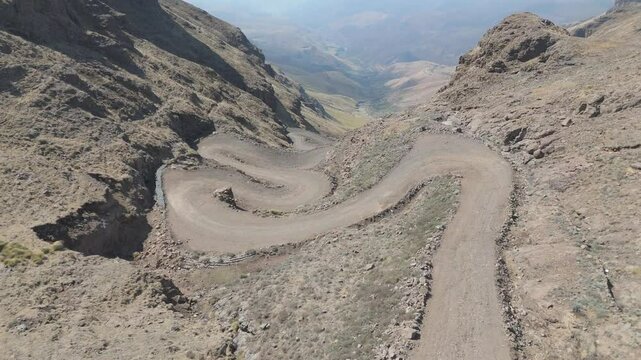 Aerial tilt down reveals treacherous and steep hairpin bends of Sani Pass