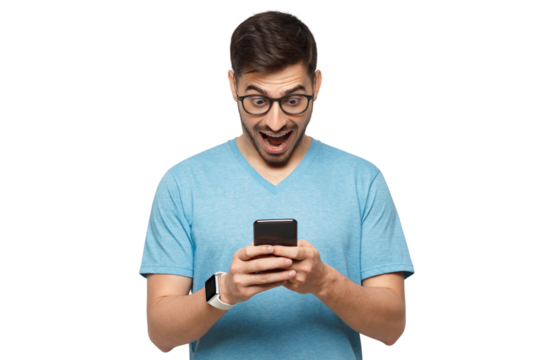 Young handsome guy dressed in blue t-shirt, wearing glasses, holding cellphone in hands, looking at screen with excited face