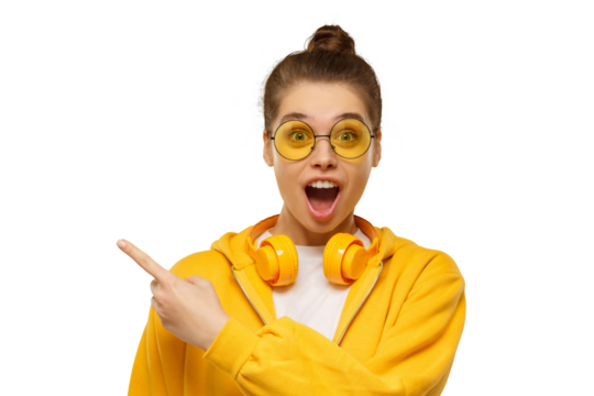 Young shocked girl, wearing round glasses and headphones on neck, pointing left - Powered by Adobe
