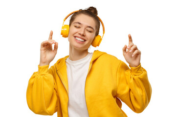 Young happy woman dancing to sounds of music in wireless headphones