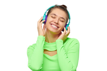 Fototapeta premium Young happy woman wearing neon green long sleeve top, listening to music through wireless headphones with closed eyes