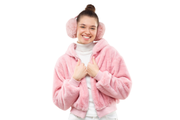 Young smiling girl wearing pink furry jacket and earmuffs, holding hands closed to chest, feeling ahy but happy