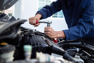 Professional mechanic working on the engine , repairing a car engine automotive workshop with a wrench, car service and maintenance,Repair service.