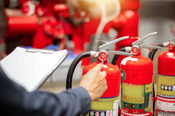 Engineer are checking and inspection a fire extinguishers tank in the fire control room for safety...