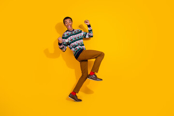 Full body photo of funny young man raise fist winning dance dressed ornament clothes christmas theme party on yellow color background