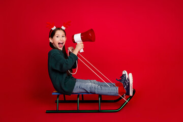 Full size photo of pretty small girl ride sledge megaphone announce wear green christmas outfit...