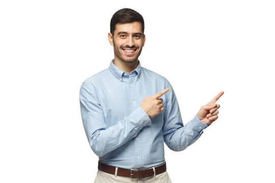 Happy smiling young businessman pointing away