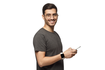 Young man standing, holding smartphone, looking at camera and smiling nicely