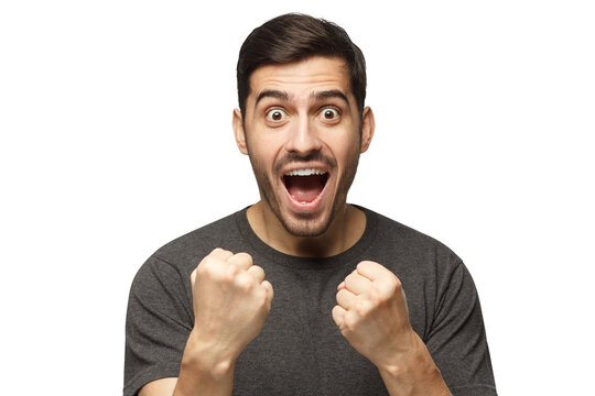 Soccer fan concept. Young attractive man shouting while his team win, raised both fist in victory gesture