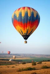 Fototapeta premium Colorful Hot Air Balloons Soaring Above Picturesque Fields During a Clear Blue Sky Morning