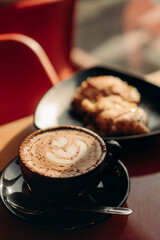 Coffee in a coffee shop with croissant in the background
