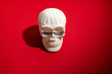 Cheerful Human skull with eyelashes on a red background. 