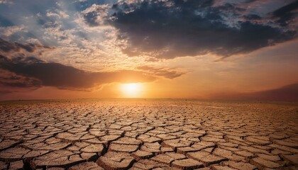 Dramatic sunset with dark clouds with cracked earth in the desert  drought in the desert with a dramatic sunset  mother nature  climate change that causes the cracks in the mud  landscape photography © intricateflow
