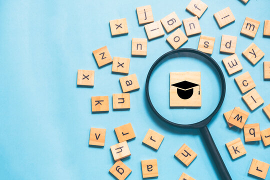 An English learning concept featuring scattered English letters with a magnifying glass highlighting a graduation cap icon