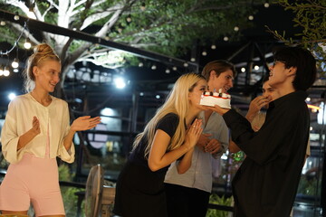  group of friends sing a happy birthday song to their girlfriend at a birthday party in a restaurant.