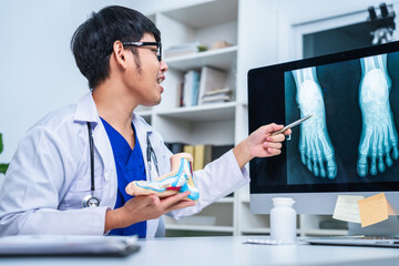 Professional Podiatrist doctor diagnose foot during medical examination of patient, doctor use foot model to explain the problem or injury of bone, structure of ankle, use x-ray to plan a surgery.