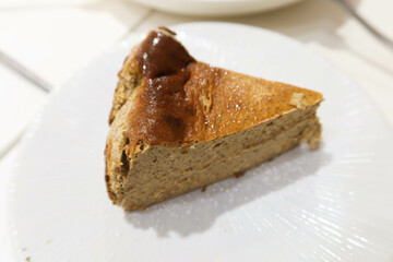 close up of a piece of earl grey tea flavour homemade baked basque cheesecake on a white plate