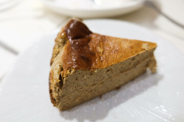 close up of a piece of earl grey tea flavour homemade baked basque cheesecake on a white plate