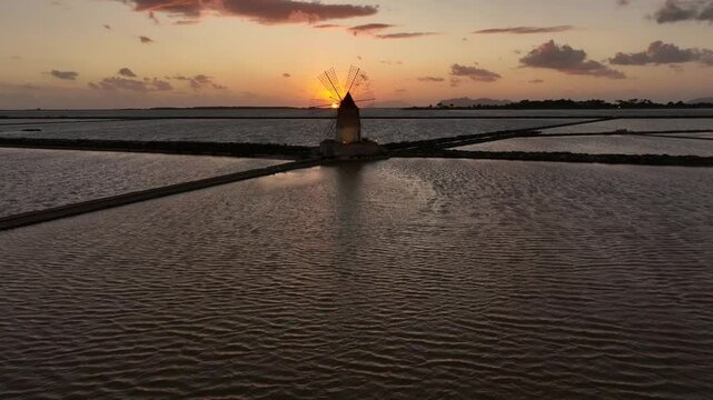 Sorvolo tra le saline di Marsala e Nubia al tramonto con visione del mulino a vento con un panorama romantico in uno scenario naturalistico ricordo di un viaggio in Olanda