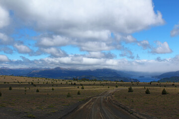 Obraz premium Natural road, and araucaria fields, heading for Alumina lagoon, all covered in giant clouds.
