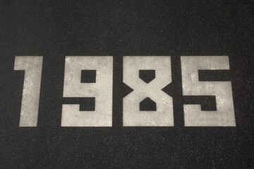 Black granite slab with white numbers 1985 on it
